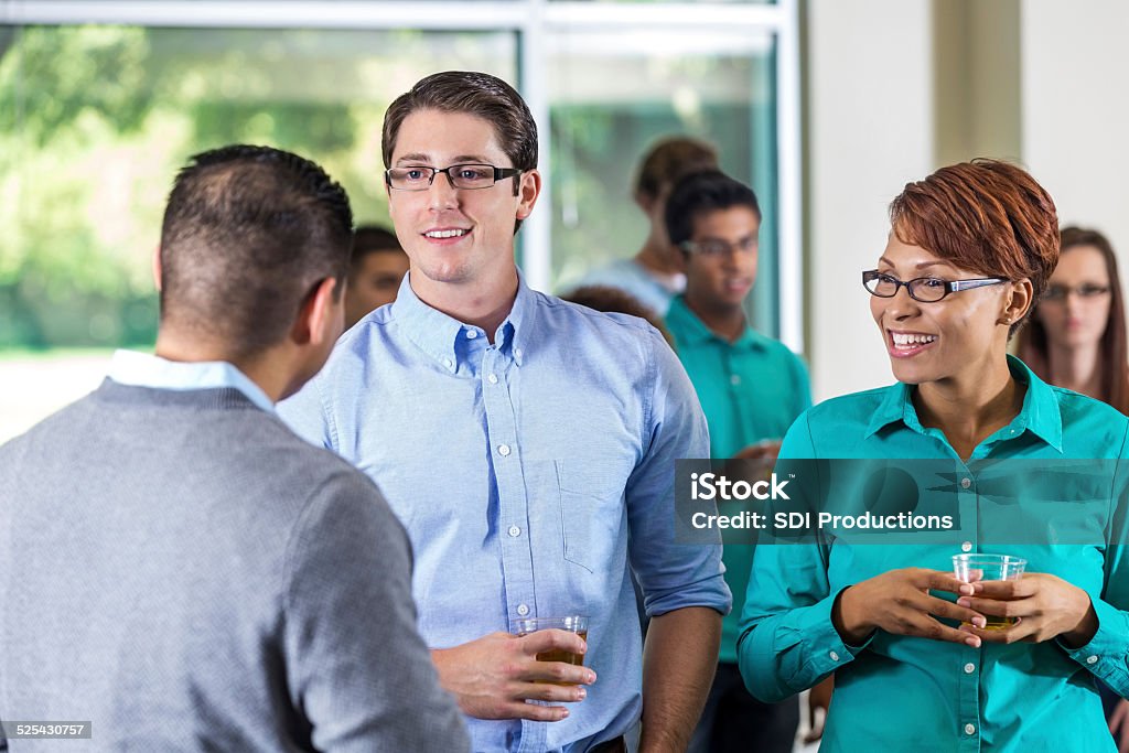 Diverse professionals talking during mixer or party event 30-39 Years Stock Photo