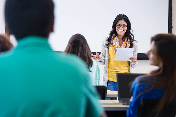 istock Pretty young Hispanic student reading report to class 525430789
