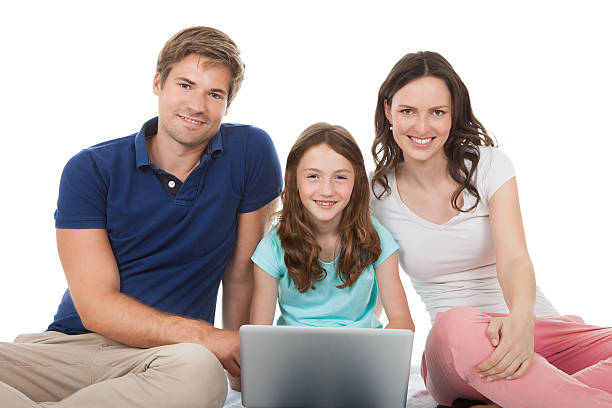istock Family Sitting With Laptop Over White Background 525432445