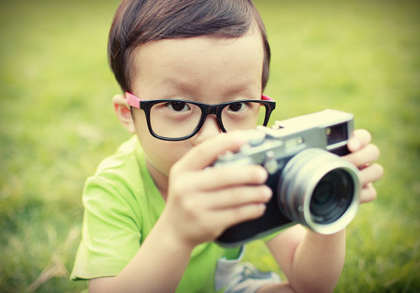 istock cute child plays the photographer 525432639