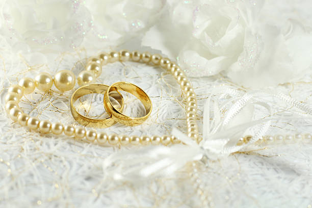istock Two golden wedding rings with seamless flower decorations 525432725