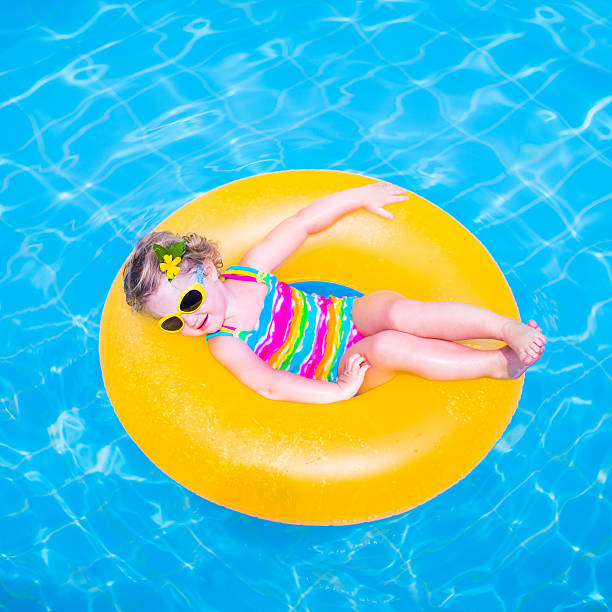 istock Little girl in a swimming pool 525433649