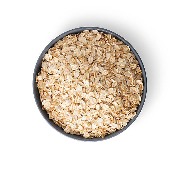 istock Oat flakes in bowl on white background 525434459