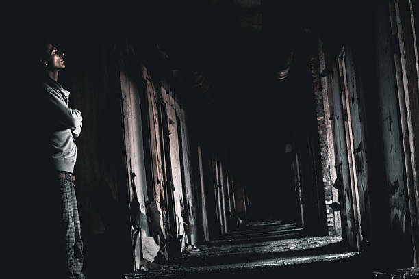 istock dark corridor and the man in a gloom 525434801