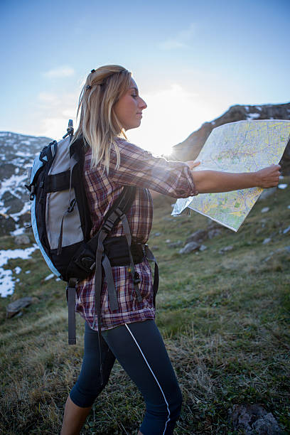 ヘルシーな女性の観光で山リーティングマップ、道順のご案内 - mountain climbing pursuit women sunset ストックフォトと画像