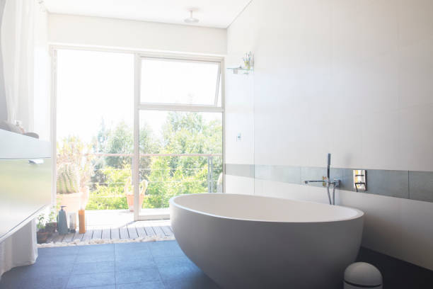 istock Modern bathroom with large white bathtub and patio door 525439907