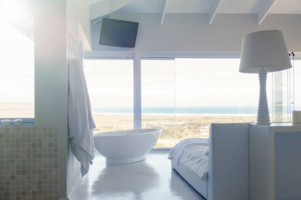 istock Modern white bedroom interior with bed large bathtub 525439941