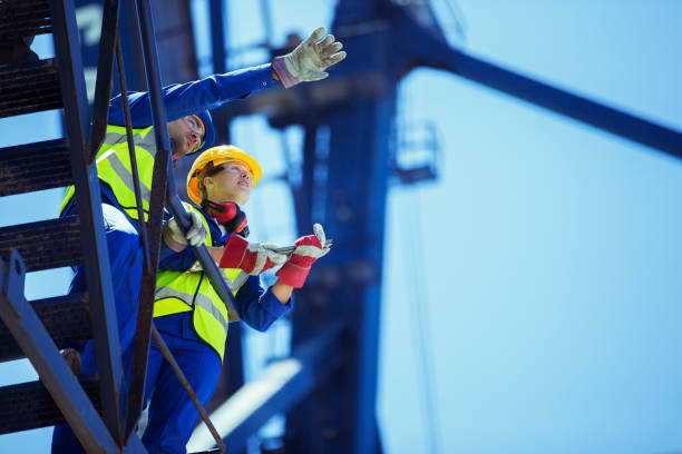 niedrige winkelansicht von arbeitern, die auf dem kran sprechen - blue helmet stock-fotos und bilder