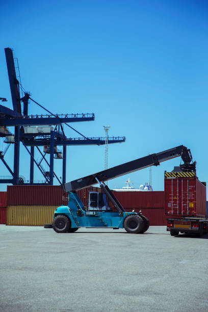 istock Crane lifting cargo container onto truck 525440447
