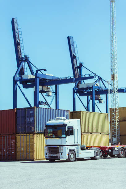 istock Cranes over cargo containers and truck 525440527