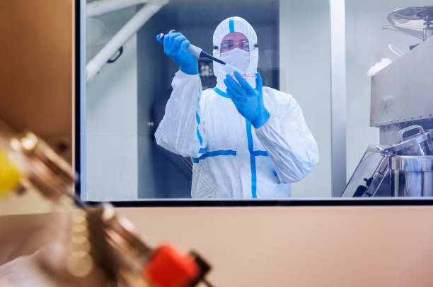istock Scientist in clean suit pipetting sample into Petri dish in laboratory 525440681