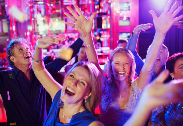 gente levantando la mano y riendo en la discoteca - vida nocturna fotografías e imágenes de stock