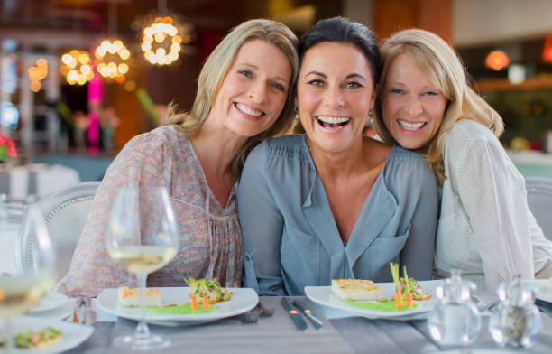 retrato de mujeres sonrientes en restaurante - restaurant sitting adult beauty fotografías e imágenes de stock