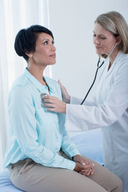 istock Female doctor examining her patient with stethoscope in office 525441411