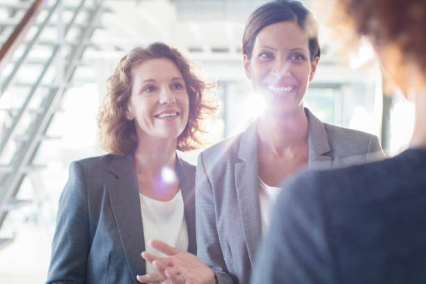 istock Three smiling businesswomen talking in office corridor 525441489
