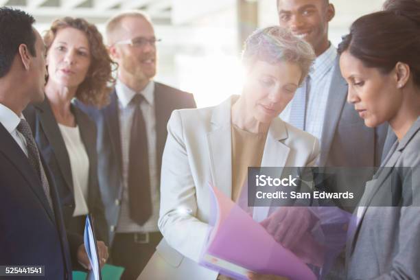 Office Team Sharing Documents At Meeting Stock Photo - Download Image Now - 25-29 Years, 35-39 Years, 40-44 Years