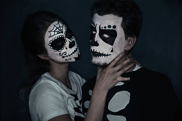Halloween couple of skeletons Halloween loving couple in costumes of skeletons and skull makeup. Woman strangles a man woman strangles man stock pictures, royalty-free photos & images