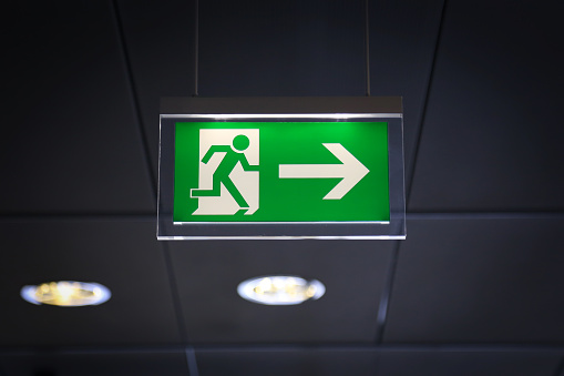 Emergency exit sign above a black doorway