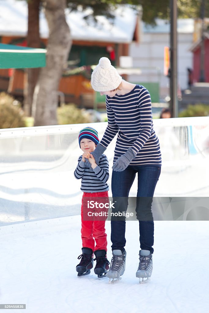family ice skating family of two having fun ice skating together at winter Active Lifestyle Stock Photo