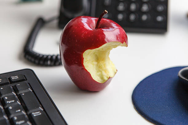 Apple on the table, healthy eating at work Apple on the table, healthy eating at work apple with bite out of it stock pictures, royalty-free photos & images