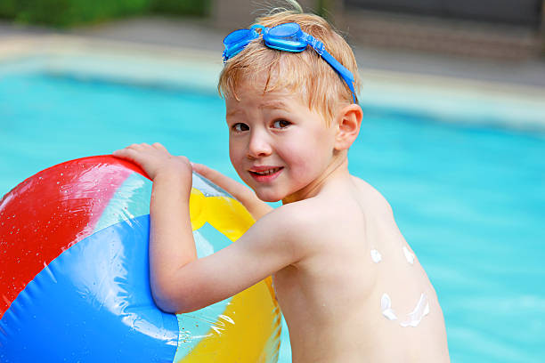 enfant s'amusant de la piscine en été - beach ball swimming pool ball child photos et images de collection