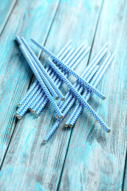 istock Striped drink straws on a blue wooden background 525470518