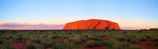 uluru bei sonnenuntergang panorama - australian culture scenics australia panoramic stock-fotos und bilder