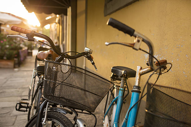 istock Italian bicycles with baskets parked on empty sunny street 525471444