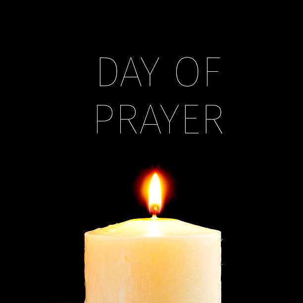 lit candle and text day of prayer a lit candle and the text day of prayer written in white against a black background national day of prayer stock pictures, royalty-free photos & images