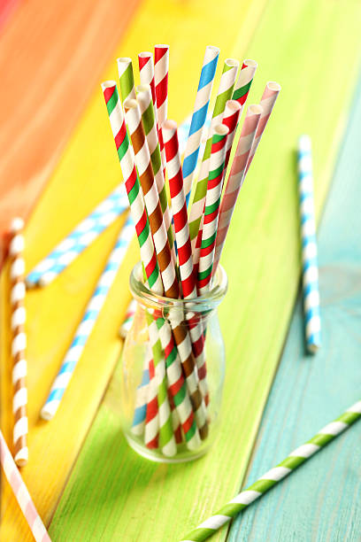 istock Striped drink straws on a colorful wooden background 525473528
