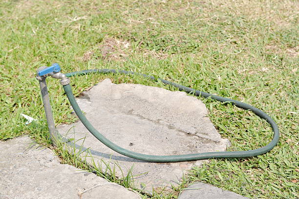 istock Rubber tube with faucet on green grass field 525473984