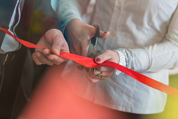 Opening ceremony with ribbon cutting Woman is cutting a red ribbon with scissors. award ribbon photos stock pictures, royalty-free photos & images