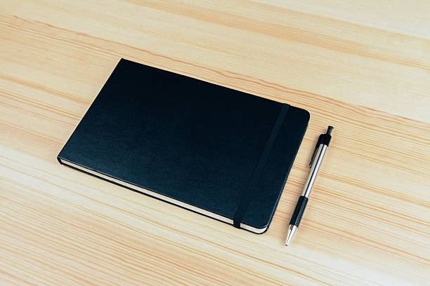 istock Blank cover of notebook with pen on wooden table 525475320