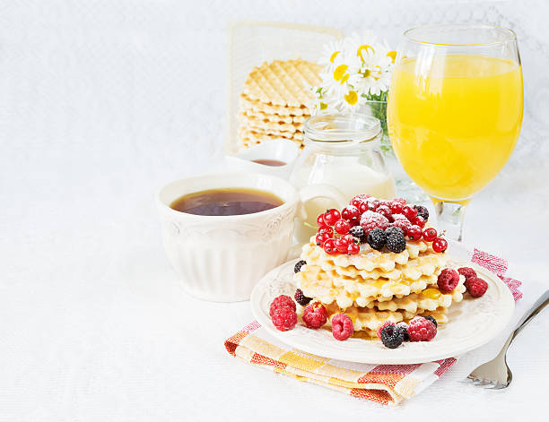 Breakfast with tea, waffles, berries and juice
