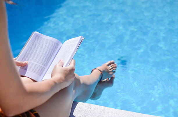 istock Girl reading by the pool 525475982