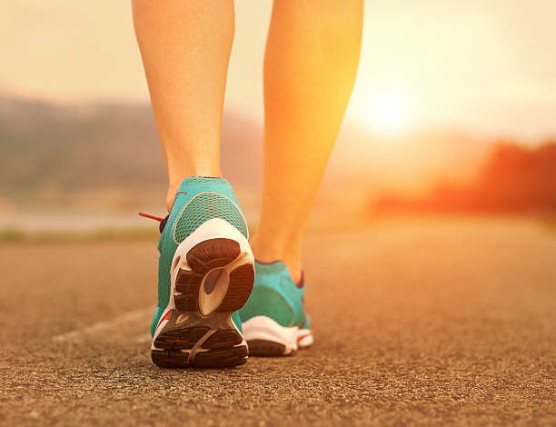 istock Runner athlete feet running on road under sunlight. 525476724