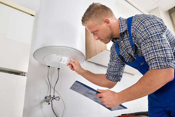 Plumbing inspector examining installed water heater in a new home