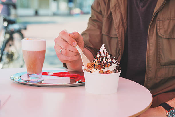 ręce człowiek jedzenie mrożony jogurt w kawiarni tabeli - caffee zdjęcia i obrazy z banku zdjęć