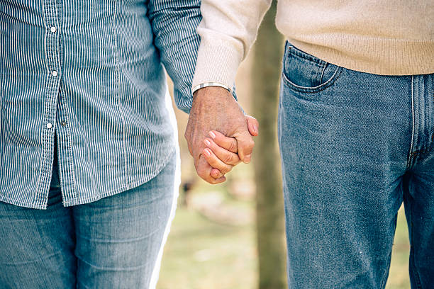 istock Senior couple holding hands over nature background 525480554