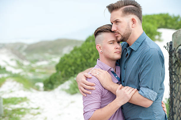 istock Gay men embracing on a fence 525481576