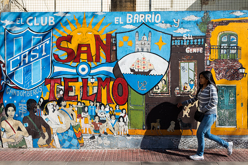Buenos Aires, Argentina - October 4, 2013: A girl passing in front of a mural in the San Telmo neighborhood, Buenos Aires, Argentina