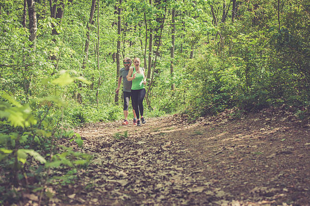 istock Young woman and elderly man running in the forest 525487808