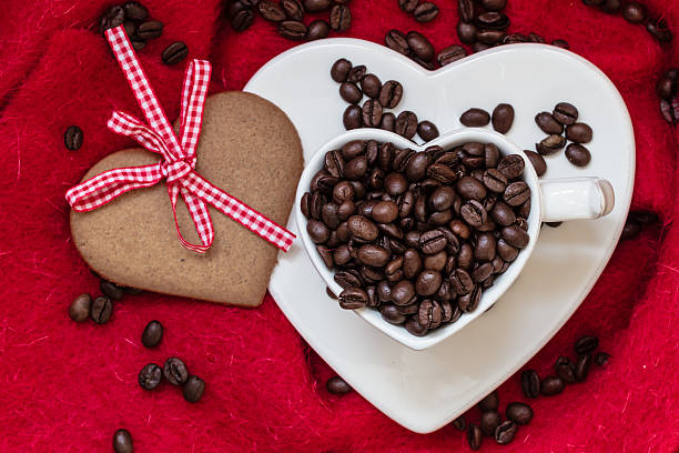 istock Coffee beans in heart shaped cup and dessert on red 525487852