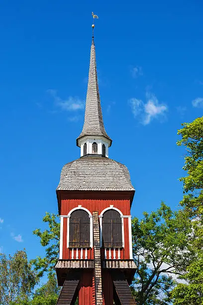 Photo of Old wooden belfry against blue sky