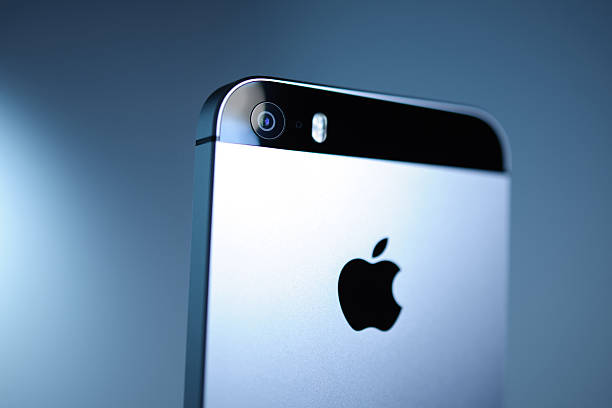 Udine, Italy - April 21, 2014: iPhone 5s model showing the home screen with iOS7 popping out from the pocket go a pair of blue vintage denim trousers