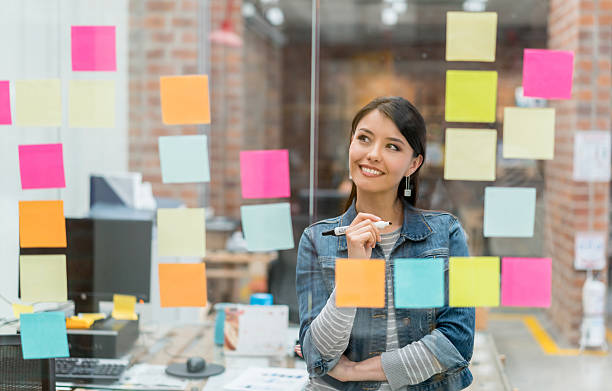 frau denkt an ideen im büro - creative thinking stock-fotos und bilder