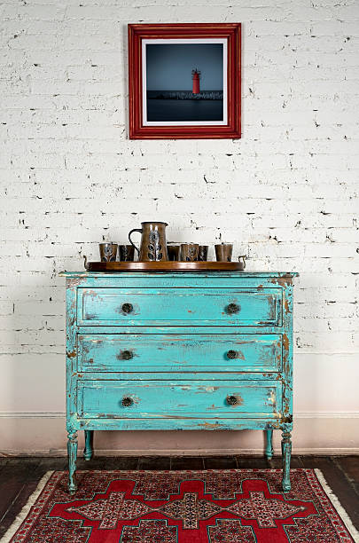 Green vintage cabinet and hanged painting on white bricks wall
