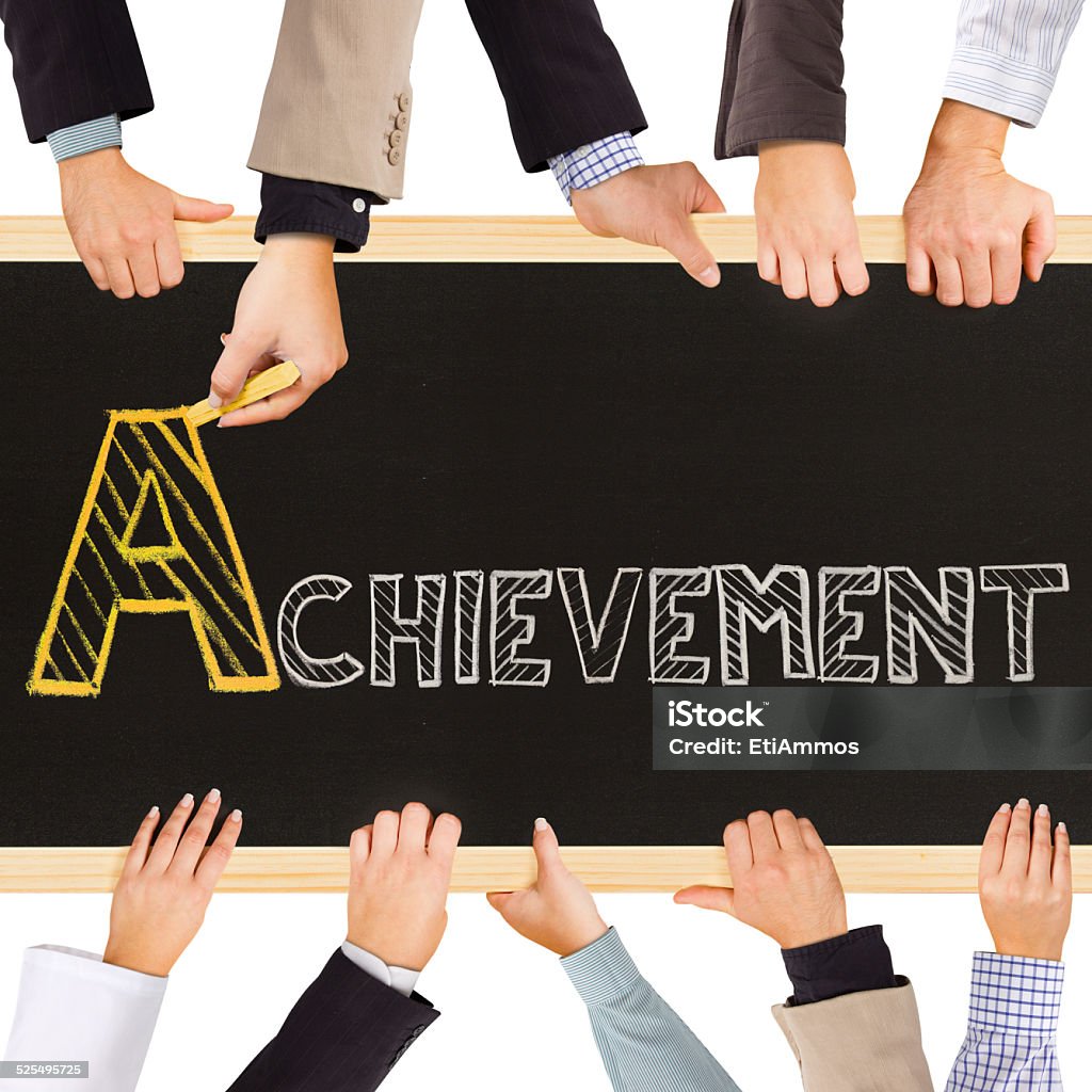Achievement concept Photo of business hands holding blackboard and writing ACHIEVEMENT concept Achievement Stock Photo