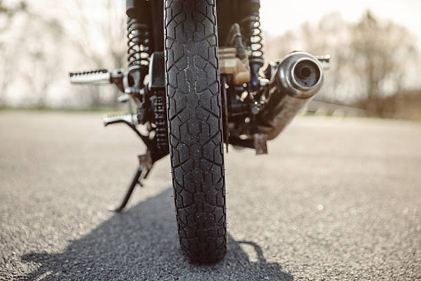 istock Wheel and exhaust pipe of motorcycle on road 525498346