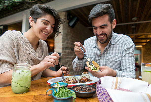 coppia felice che mangia in un ristorante - cucina messicana foto e immagini stock